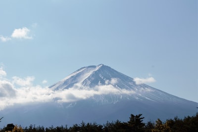 白天多云的天空下被雪覆盖的山